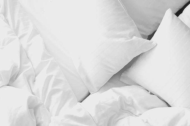 Unmade bed with white sheets